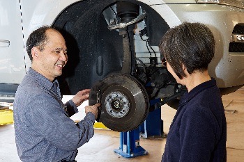 Ben from Hong Kong Auto Service shows customer what work needs to be done on her car